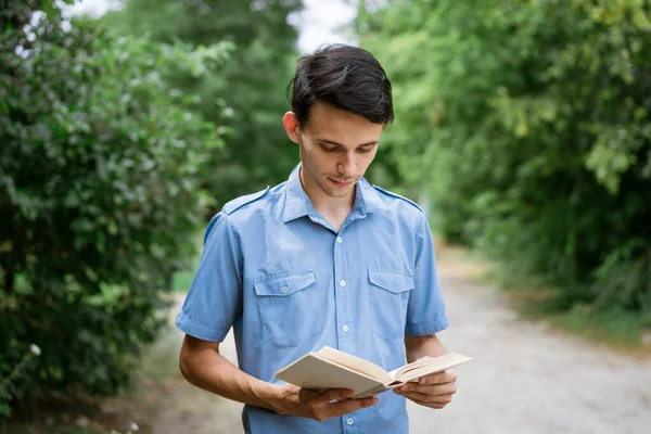 Student with book in hand in the park