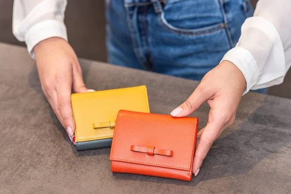 En flicka håller i handen två olika plånböcker — Stockfoto