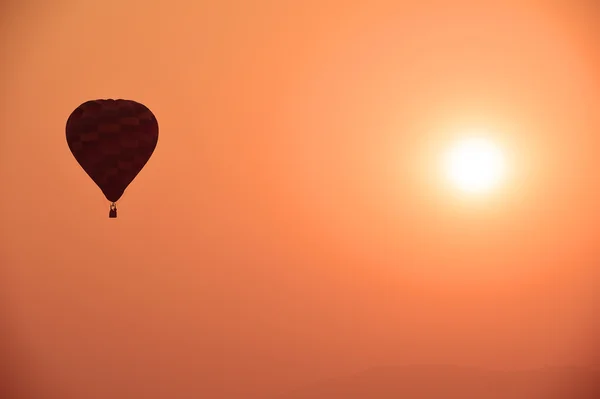 Bunter Heißluftballon fliegt bei Sonnenuntergang — Stockfoto