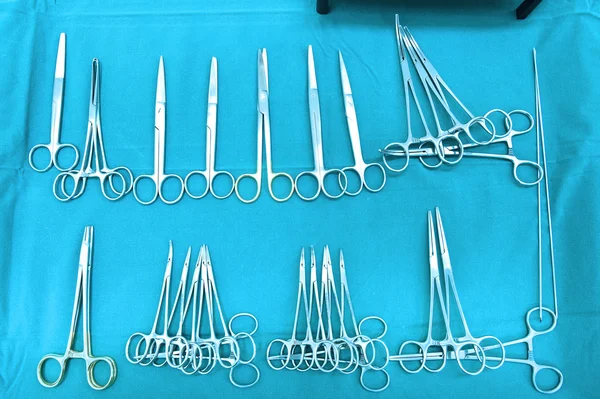 Detalhe tiro de instrumentos de cirurgia esterilizados com uma mão agarrando uma ferramenta — Fotografia de Stock