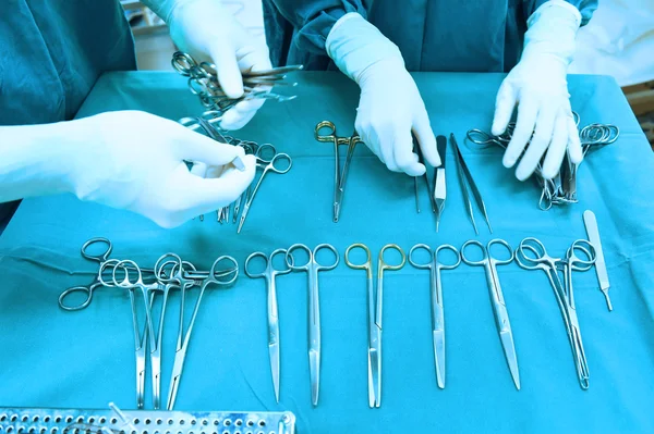 Detalhe tiro de instrumentos de cirurgia esterilizados com uma mão agarrando uma ferramenta — Fotografia de Stock