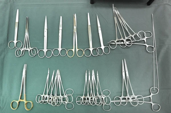 Detalhe tiro de instrumentos de cirurgia esterilizados com uma mão agarrando uma ferramenta — Fotografia de Stock