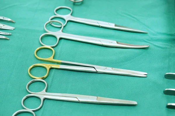 Detalle plano de instrumentos de cirugía esteralizada con una mano agarrando una herramienta —  Fotos de Stock