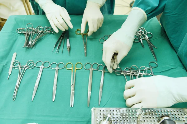 Detalle plano de instrumentos de cirugía esteralizada con una mano agarrando una herramienta — Foto de Stock