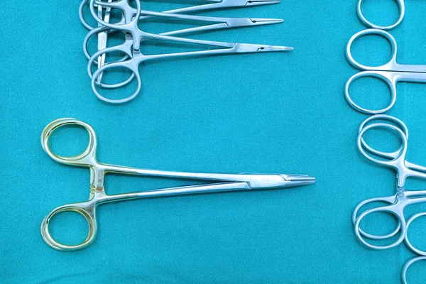 Detalle plano de instrumentos de cirugía esteralizada con una mano agarrando una herramienta —  Fotos de Stock