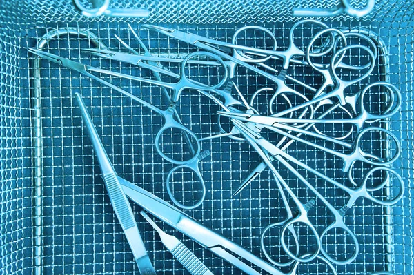 Detail shot of steralized surgery instruments with a hand grabbing a tool — Stock Photo, Image