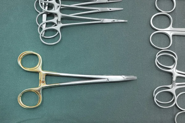 Detailaufnahme steriler Operationsinstrumente mit einer Hand, die ein Werkzeug ergreift — Stockfoto