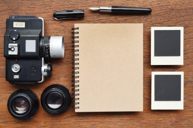 Defter kalem, fotoğraf çerçeveleri ve kamera ile 