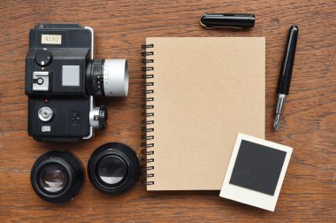 Defter kalem, fotoğraf çerçeveleri ve kamera ile 