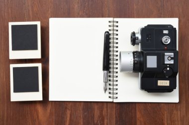 Boş defter kalem, fotoğraf çerçeveleri ve kamera ile 