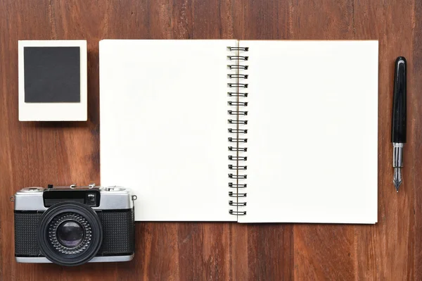 Caderno em branco com caneta, molduras para fotos e câmera — Fotografia de Stock