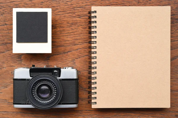 Prázdné notebook s fotorámečky a fotoaparát — Stock fotografie