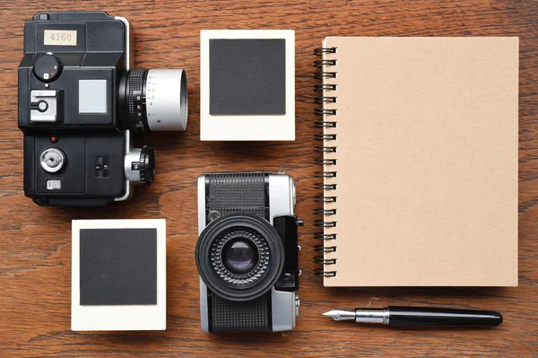 Prázdný zápisník s perem, fotorámečky a fotoaparát — Stock fotografie