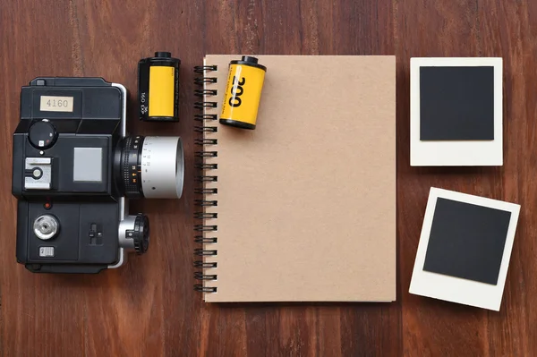 Cuaderno en blanco con película fotográfica, marcos fotográficos y cámara —  Fotos de Stock