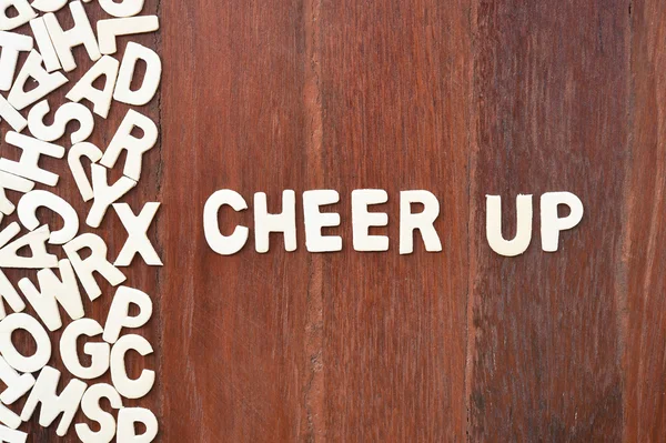 Word cheer up made with block wooden letters