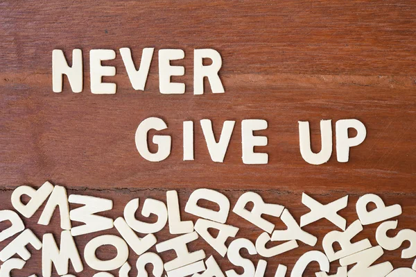 Palavra nunca desistir feito com letras de madeira bloco — Fotografia de Stock