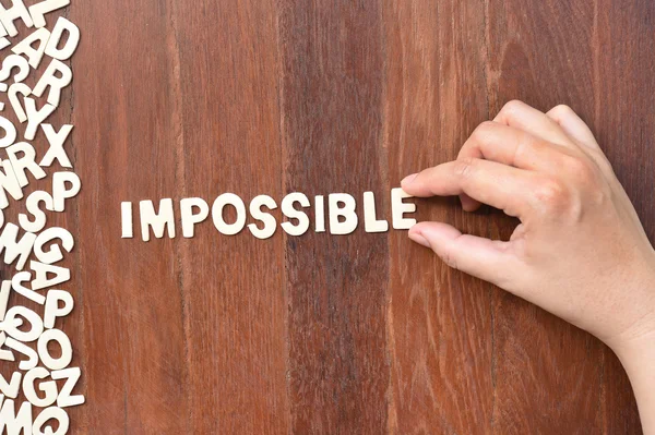 Word impossible made with block wooden letters — Stock Photo, Image