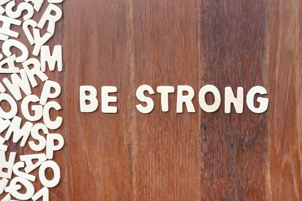 Palavra ser forte feito com letras de madeira bloco — Fotografia de Stock