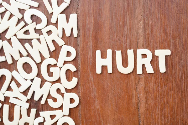 Word hurt made with block wooden letters