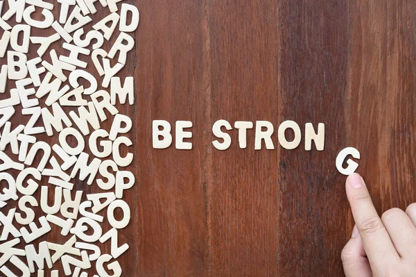 Palavra ser forte feito com letras de madeira bloco — Fotografia de Stock