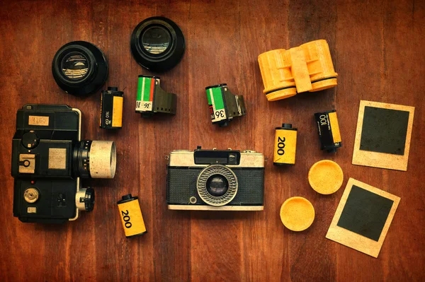 Película fotográfica con fotogramas y cámara sobre fondo de madera —  Fotos de Stock