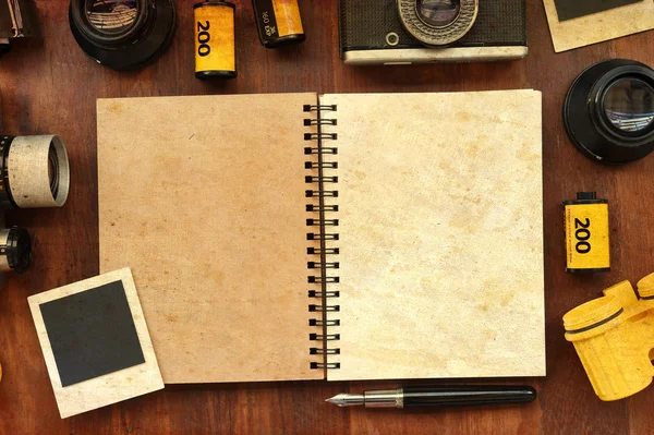 Cuaderno en blanco con película fotográfica y cámara sobre fondo de madera —  Fotos de Stock