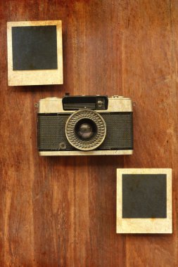 Fotoğraf çerçeveleri ve ahşap arka plan üzerinde kamera 