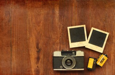 Foto film ile fotoğraf çerçeveleri ve ahşap arka plan üzerinde fotoğraf makinesi 