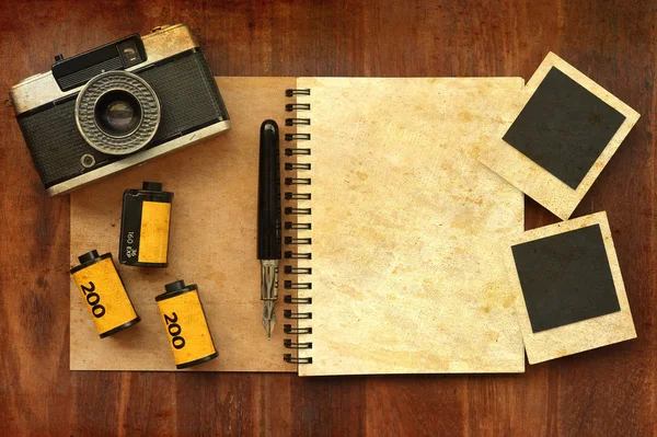 Κενό σημειωματάριο με φωτογραφία ταινία και φωτογραφική μηχανή, σε ξύλινα φόντο — Φωτογραφία Αρχείου