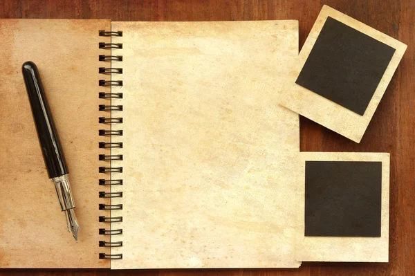 Cuaderno en blanco con película fotográfica y cámara sobre fondo de madera — Foto de Stock