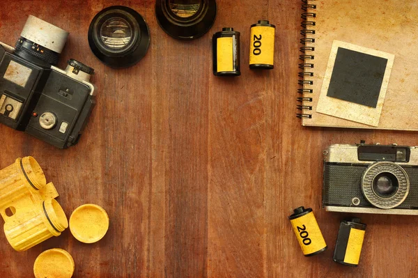 Caderno em branco com filme fotográfico e câmera em fundo de madeira — Fotografia de Stock