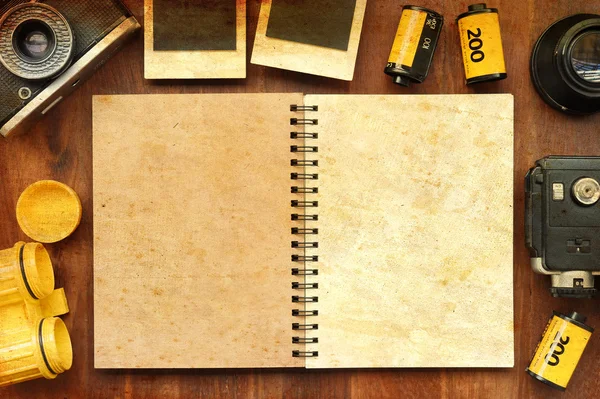 Blank notebook with photo film and camera on wooden background — Stock Photo, Image