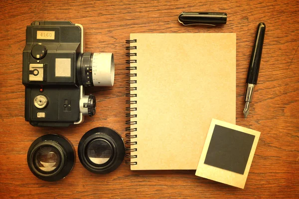 Leeres Notizbuch mit Stift, Fotorahmen und Kamera auf Holzgrund — Stockfoto