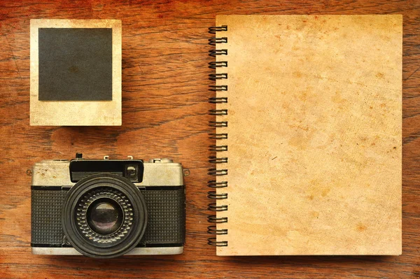 Blank notebook with photo frames and camera on wooden background — Stock Photo, Image