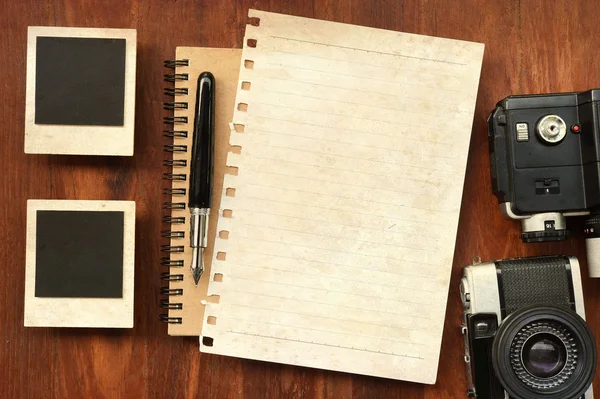 Papel en blanco con lápiz, marcos de fotos y cámara sobre fondo de madera —  Fotos de Stock