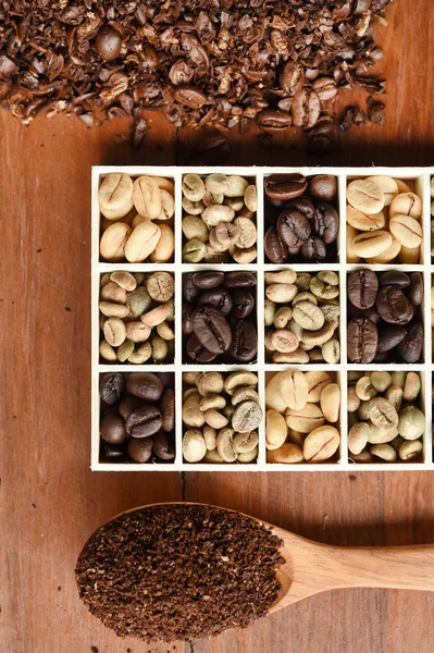 different coffee forms in wooden box and ground coffee in wooden spoon