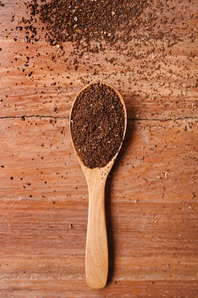 Ground coffee in wooden spoon