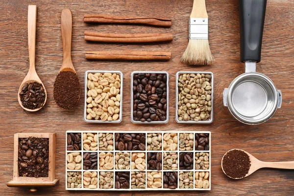 Coffee beans with ground coffee in wooden spoon and cinnamon — Stock Photo, Image