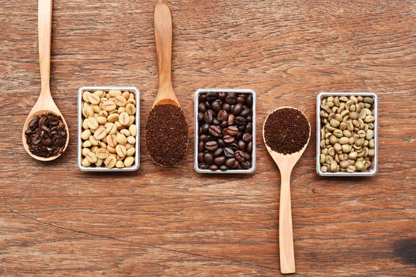 Granos de café y café molido en cuchara de madera — Foto de Stock