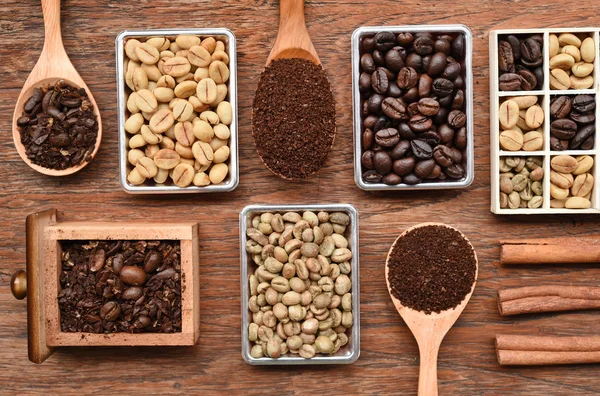 Coffee beans with ground coffee in wooden spoon and cinnamon