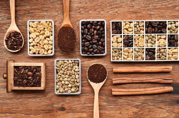 Coffee beans with ground coffee in wooden spoon and cinnamon