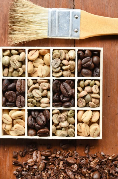 Diferentes formas de café en caja de madera y cepillo — Foto de Stock