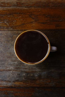 Bir fincan kahveyi ahşap arka planda kapat.                                 