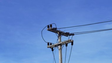 Mavi gökyüzü arkaplanlı elektrik direğindeki elektrik hatları için ekipman