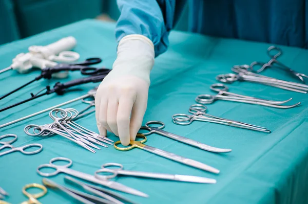 Steralized surgery instruments with a hand grabbing a tool — Stock Photo, Image