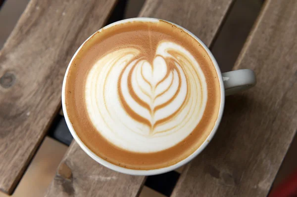 Una taza de café con leche arte en la mesa — Foto de Stock