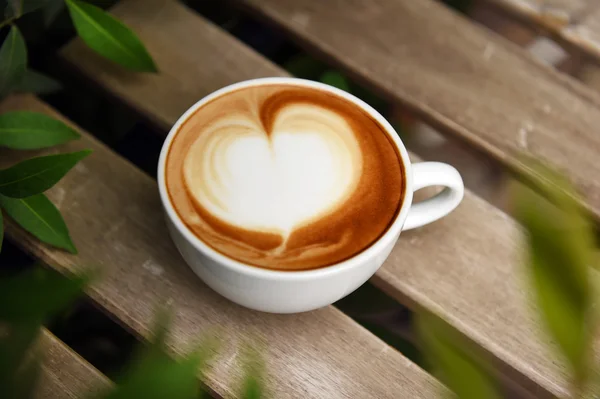 Kubek latte art kawy na stole — Zdjęcie stockowe