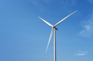 Bulutlu mavi gökyüzü arkaplanına karşı rüzgar türbini