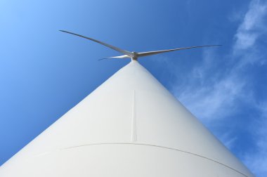 Bulutlu mavi gökyüzü arkaplanına karşı rüzgar türbini