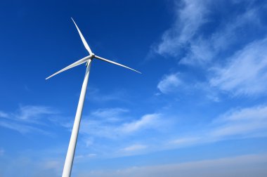 Bulutlu mavi gökyüzü arkaplanına karşı rüzgar türbini